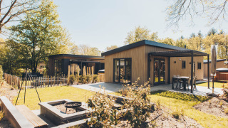 Casa Loevestein Deluxe con jacuzzi, terraza moderna, área de fogata y jardín en entorno boscoso.