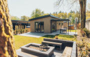 Lodge Loevestein Deluxe al parco Veluwe de Bosgraaf, Paesi Bassi, con patio e zona barbecue all’aperto.