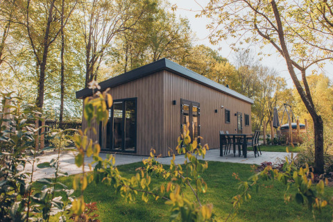 Lodge Loevestein en bois moderne au parc de Bosgraaf, Pays-Bas, entouré de verdure et terrasse extérieure.