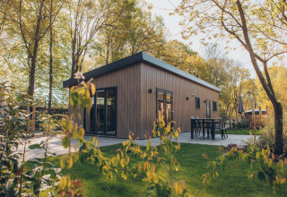 Lodge Loevestein en bois moderne au parc de Bosgraaf, Pays-Bas, entouré de verdure et terrasse extérieure.