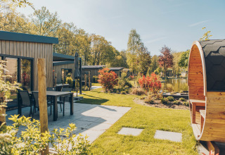 Día soleado en la cabaña Loevestein Deluxe en Veluwe park de Bosgraaf, con terraza y sauna de barril.