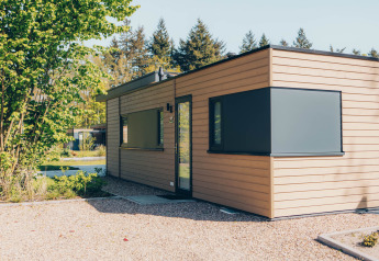 Moderno lodge in legno chiamato 'Cannenburch' nel Veluwe park de Bosgraaf, Paesi Bassi, tra alberi e natura.
