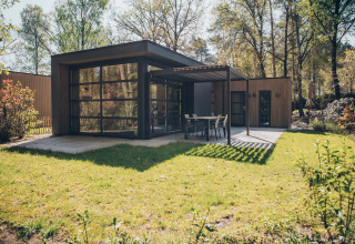 Moderne Bosvilla Comfort-Lodge mit Terrasse und großen Fenstern im Grünen im Veluwe Park de Bosgraaf, Niederlande.