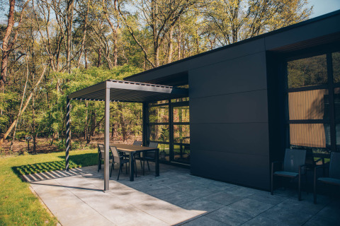 Terrasse extérieure moderne à la Bosvilla Comfort dans Veluwe park de Bosgraaf, Pays-Bas, en lisière de forêt.