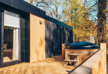 Terrazza con vasca idromassaggio al lodge Valkhof met Hottub nel parco Veluwe de Bosgraaf, Paesi Bassi.