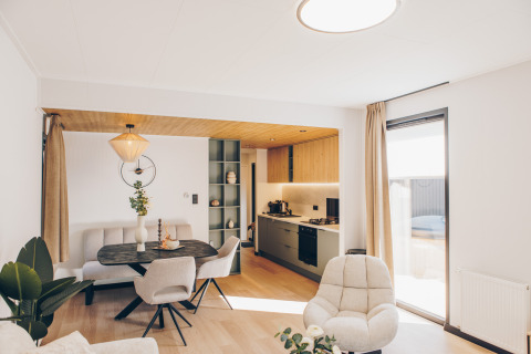 Área de sala y cocina moderna de lodge con luz natural en Valkhof met Hottub, Veluwe park de Bosgraaf, Países Bajos.