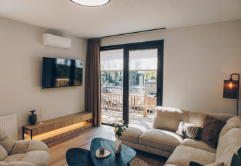 Acogedora sala en Valkhof met Hottub lodge en Veluwe park de Bosgraaf con decoración moderna y grandes ventanales.