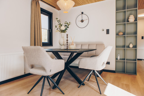 Moderne eetruimte met lichte stoelen, bank en tafel bij Valkhof met Hottub, Veluwe park de Bosgraaf.