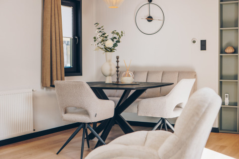 Comedor moderno con sillas cómodas y mesa redonda en Valkhof met Hottub en Veluwe park de Bosgraaf.