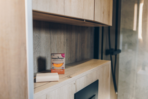 Baño de madera con caja de jabón HappySoaps y una pastilla en estante en Valkhof met Hottub, Veluwe park de Bosgraaf.