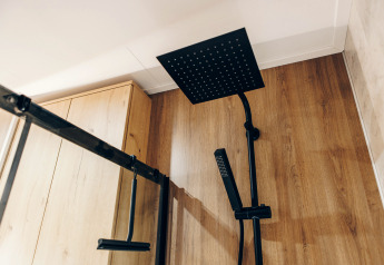 Modern black shower with wooden wall at Valkhof met Hottub, Veluwe park de Bosgraaf, Netherlands.