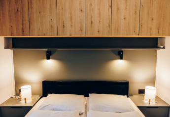 Contemporary bedroom at Valkhof met Hottub, Veluwe park de Bosgraaf, Netherlands, with wood cabinets and lamps.