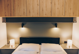 Dormitorio moderno con armarios de madera en Valkhof met Hottub, Veluwe park de Bosgraaf, Países Bajos.