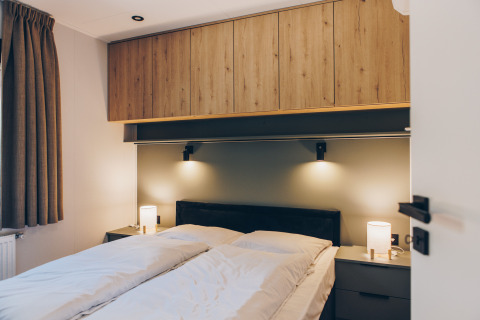 Dormitorio moderno en Valkhof met Hottub en Veluwe park de Bosgraaf, Países Bajos, con armarios de madera.