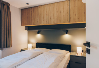 Moderne slaapkamer bij Valkhof met Hottub in Veluwe park de Bosgraaf, Nederland, met houten kasten.