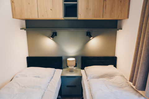 Habitación moderna con dos camas individuales y lámparas en Valkhof met Hottub, Veluwe park de Bosgraaf, Países Bajos.