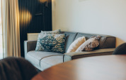 Divano moderno con cuscini decorativi in una sistemazione glamping, atmosfera accogliente e di stile.