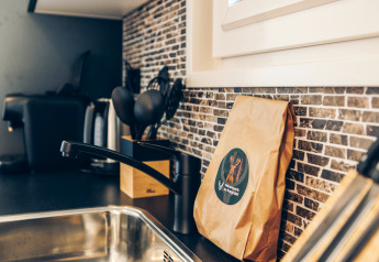 Küchenbereich einer Glamping-Unterkunft mit Spüle, Kaffeemaschine, Küchenutensilien und Tüte.