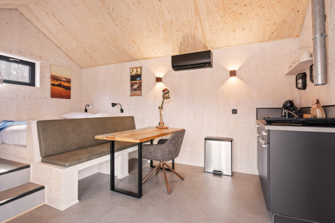 Interni di una tiny house moderna presso Nature house 'Barn', campeggio Si-Es-An, Paesi Bassi, con cucina.