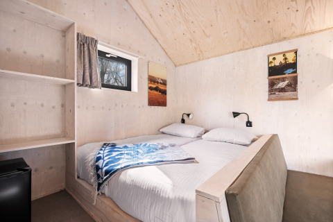 Habitación en la casa de naturaleza «Barn» del camping Si-Es-An en Países Bajos, con cama doble.
