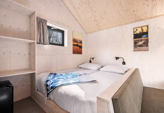Camera da letto nella Nature house «Barn» al campeggio Si-Es-An, Paesi Bassi, con pareti in legno.