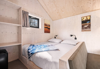 Camera da letto nella Nature house «Barn» al campeggio Si-Es-An, Paesi Bassi, con pareti in legno.