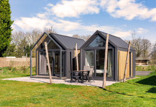 Modern tiny house with glass facade and outdoor patio at Campsite Si-Es-An in the Netherlands