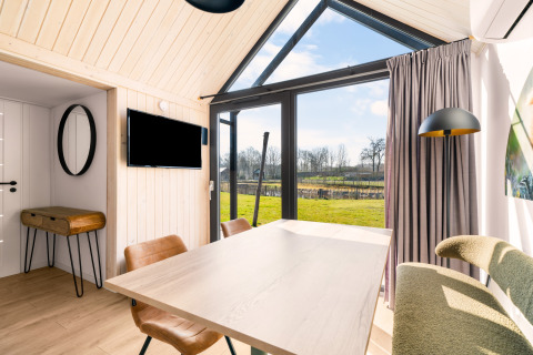 Cozy tiny house at Campsite Si-Es-An, Netherlands, featuring large windows and scenic views of nature.