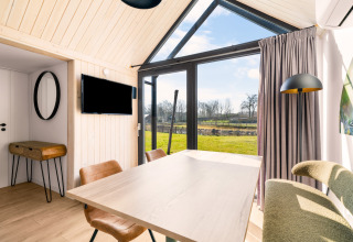 Tiny house confortable au camping Si-Es-An, Pays-Bas, avec grandes fenêtres et vue sur la nature.