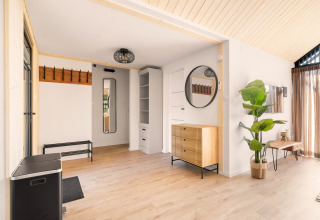 Lyst og moderne interiørbillede af Cosy Lodge på Campingplads Si-Es-An i Holland med træfinish.