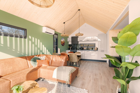 Bright, modern interior of Cosy Lodge at Campsite Si-Es-An in the Netherlands with green and wood accents.