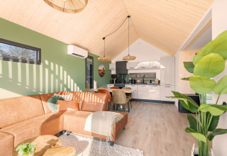 Bright, modern interior of Cosy Lodge at Campsite Si-Es-An in the Netherlands with green and wood accents.