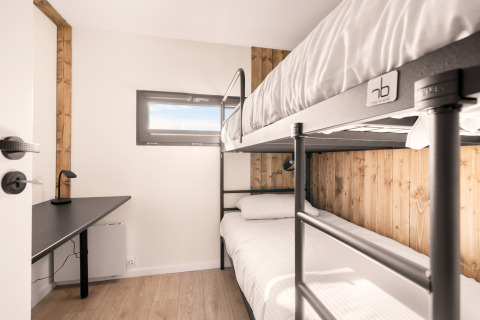 Camera con letto a castello, scrivania e finestra al Cosy Lodge, Campeggio Si-Es-An, Paesi Bassi.