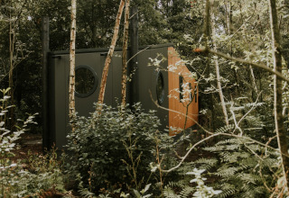 Happy Bee Lodge nestled in lush forest at Campsite Si-Es-An, Netherlands, cozy modern cabin in nature.
