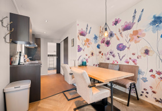 Zona pranzo alla Happy Bee Lodge con parete floreale colorata e arredamento moderno nei Paesi Bassi.