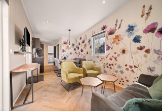 Soggiorno nella Happy bee lodge al campeggio Si-Es-An, Paesi Bassi, con decorazione murale floreale moderna.