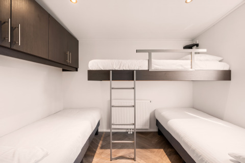 Modern lodge room at Happy bee lodge, Campsite Si-Es-An, Netherlands, with three beds and built-in cupboards.