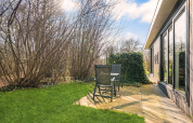 Sunny patio at luxury tiny house at Campsite Si-Es-An, Netherlands, with chairs and green surroundings