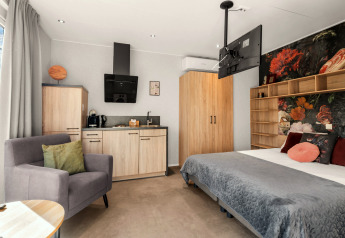 Luxe tiny house loft met kitchenette en comfortabel bed op Camping Si-Es-An in Nederland.