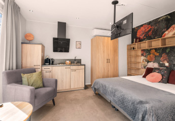 Tiny house di lusso in stile loft con angolo cottura e letto accogliente al campeggio Si-Es-An nei Paesi Bassi.