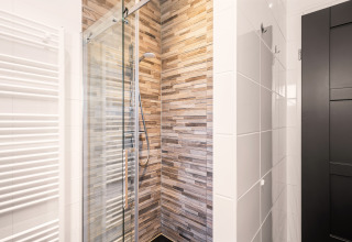Doccia moderna con porta in vetro e piastrelle effetto legno nel bagno compatto del Luxury Loft a Si-Es-An.