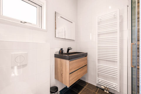 Salle de bain moderne dans le tiny house Luxury loft du Camping Si-Es-An, Pays-Bas, avec meuble bois.