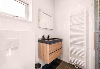 Bagno moderno nel tiny house Luxury loft al campeggio Si-Es-An, Paesi Bassi, con lavabo in legno.