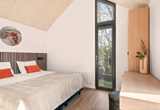 Moderne lodge soveværelse på Reestdal, Campsite Si-Es-An, med træloft og store vinduer, Holland.
