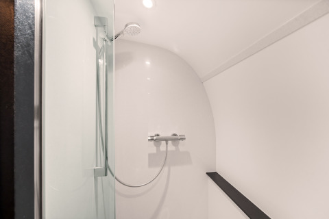 Modern shower inside the Nature house 'Skycabin' at Campsite Si-Es-An, Netherlands, with glass panel.