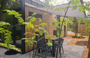 Petit espace extérieur devant une tiny house au camping Si-Es-An aux Pays-Bas, entouré de verdure.