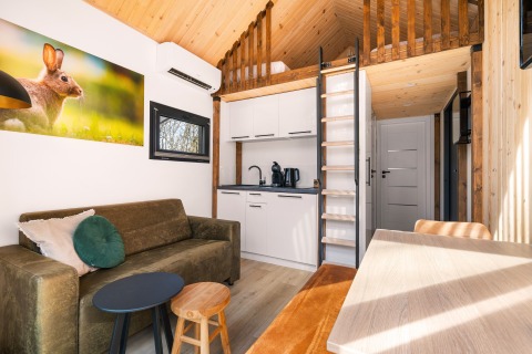 Soggiorno accogliente e angolo cottura in una Tiny House al Campeggio Si-Es-An nei Paesi Bassi.