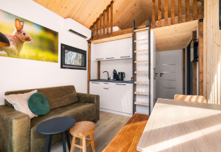 Soggiorno accogliente e angolo cottura in una Tiny House al Campeggio Si-Es-An nei Paesi Bassi.
