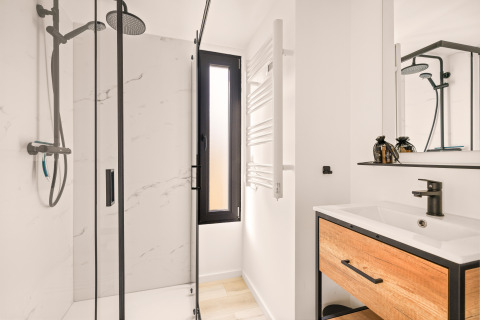 Modern, compact bathroom in a tiny house at Campsite Si-Es-An in the Netherlands, featuring shower and sink.
