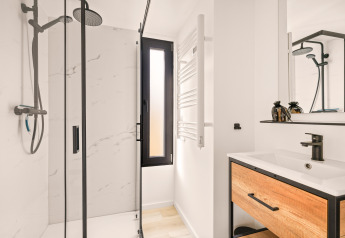Baño moderno y compacto en una tiny house en el Camping Si-Es-An, Países Bajos, con ducha y lavabo.
